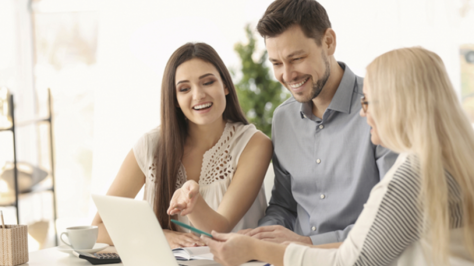 Eltern und Tochter schauen auf einen Laptop