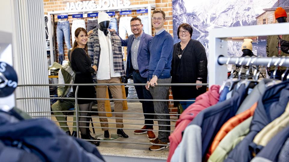Estervan (li.) absolviert eine Ausbildung zur Einzelhandelskauffrau im Modehaus Brörmann. MaßArbeit-Vorstand Lars Hellmers (v. li.), Modehaus-Inhaber Frank Brörmann und Vanessa Groth, Vermittlerin in der Außenstelle der MaßArbeit in Ostercappeln, freuen sich, dass sich die Syrerin so gut integriert hat.  Foto: Miriam Loeskow-Bücker / MaßArbeit  