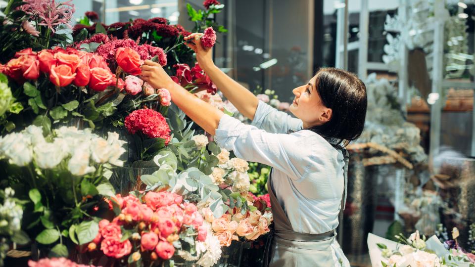 Eine Floristin arrangiert Blumensträuße in einem Blumenladen
