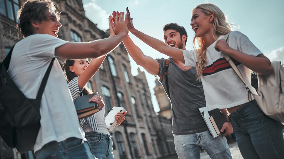 Eine Gruppe junger Menschen klatscht sich mit den Händen ab