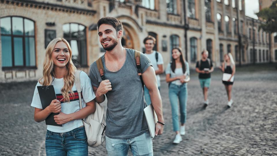 Junge Leute, die von einem Schulgebäude weggehen
