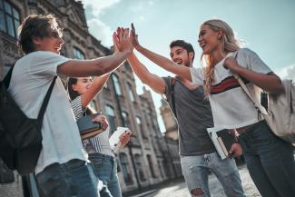 Eine Gruppe junger Menschen klatscht sich mit den Händen ab